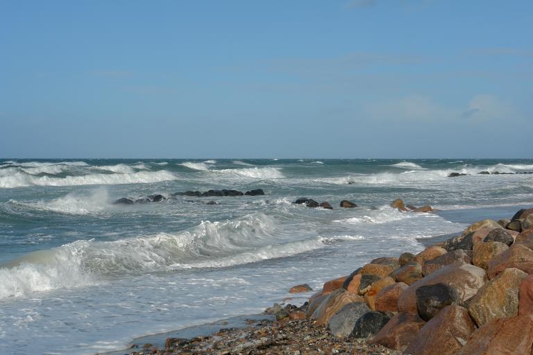 Bølger, der slår ind mod kysten i blæsevejr